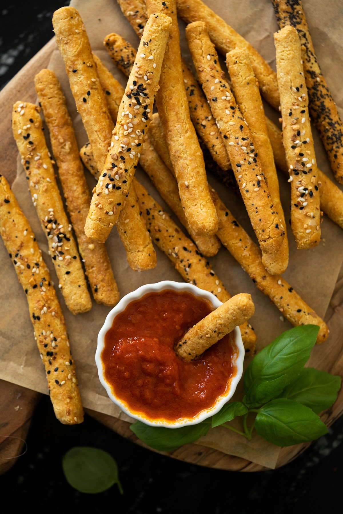 Keto breadsticks on a wooden board served with marinara sauce
