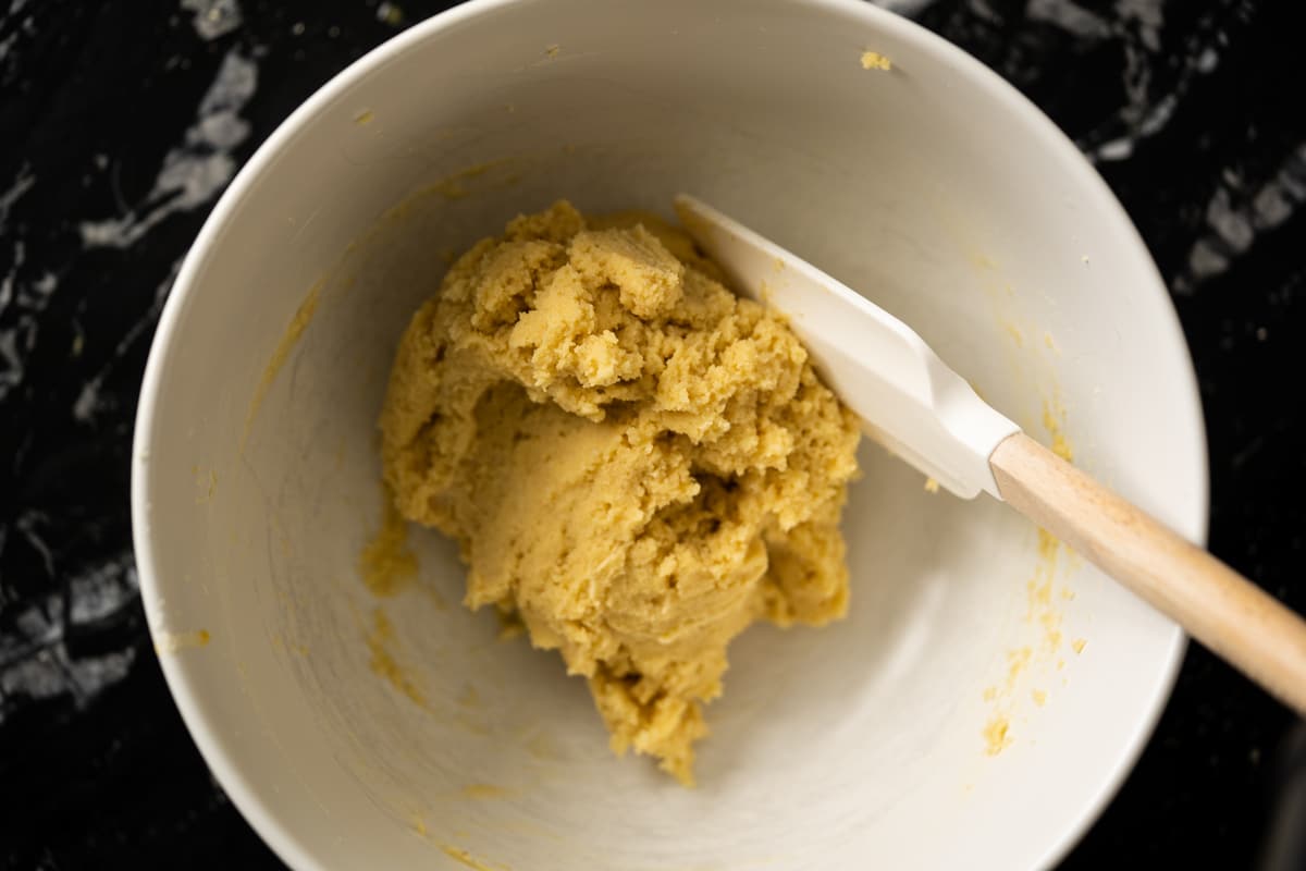 The keto breadstick dough in a white mixing bowl with a spatula