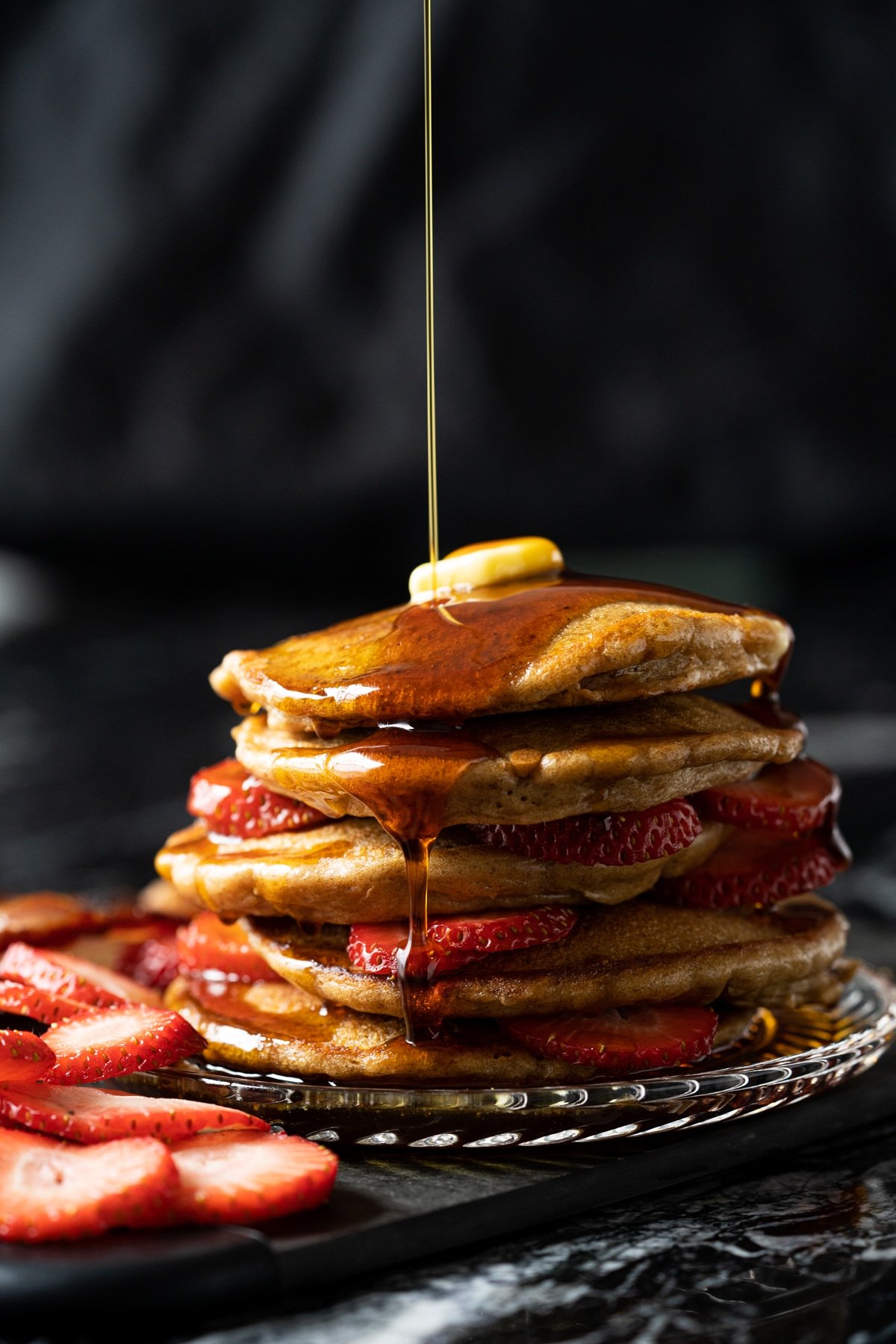 A stack of flourless keto pancakes with butter and sugar free maple syrup