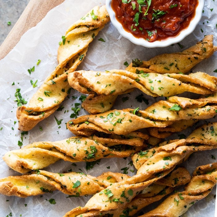 Garlic keto breadsticks with fresh parsley and marinara sauce