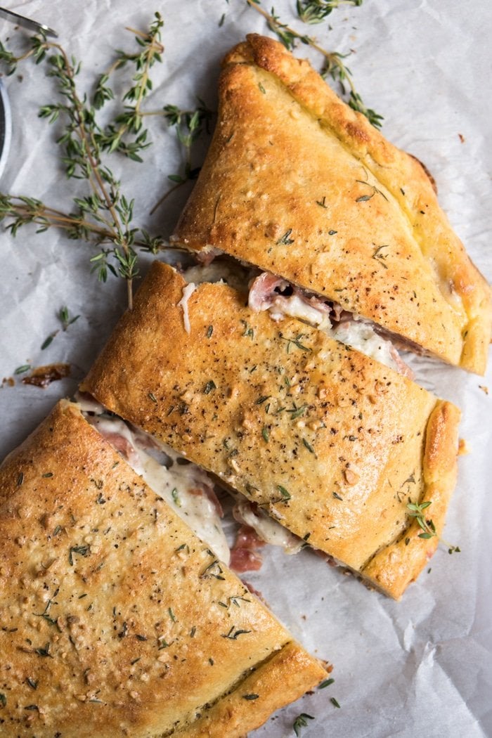 Closeup keto calzone on parchment paper with fresh thyme
