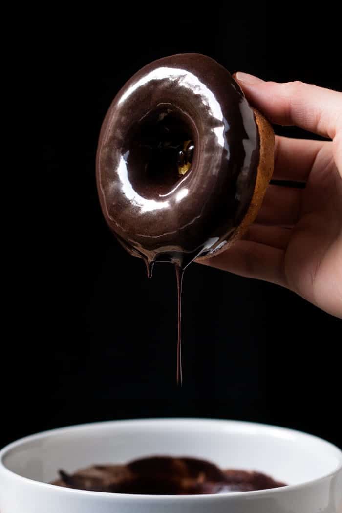 Dipping a keto donut in chocolate glaze