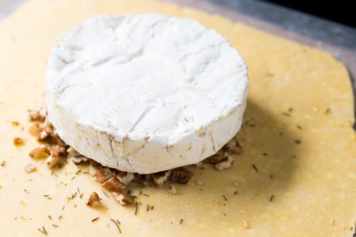 A wheel of brie over pecans and pie crust dough