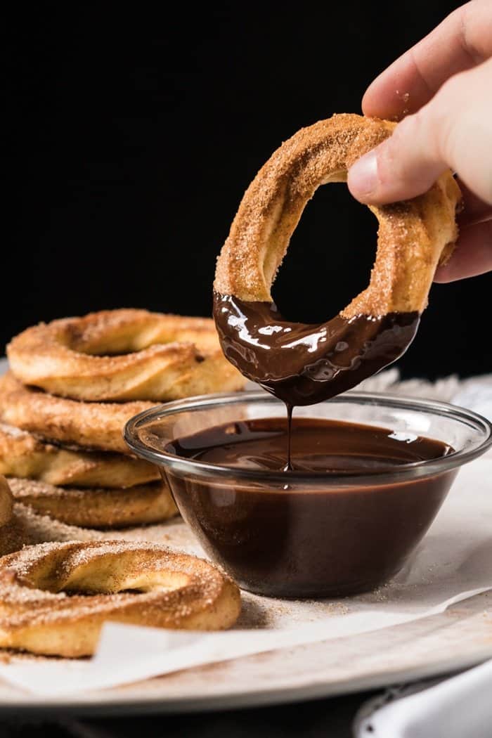 Dipping a keto churro donut in chocolate sauce