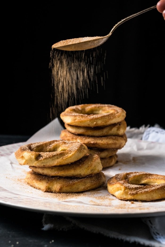 Sprinkling cinnamon 'sugar' onto keto churro donuts