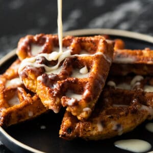 Gluten free & keto cinnamon roll waffles with yeast and a drizzle of cream cheese glaze