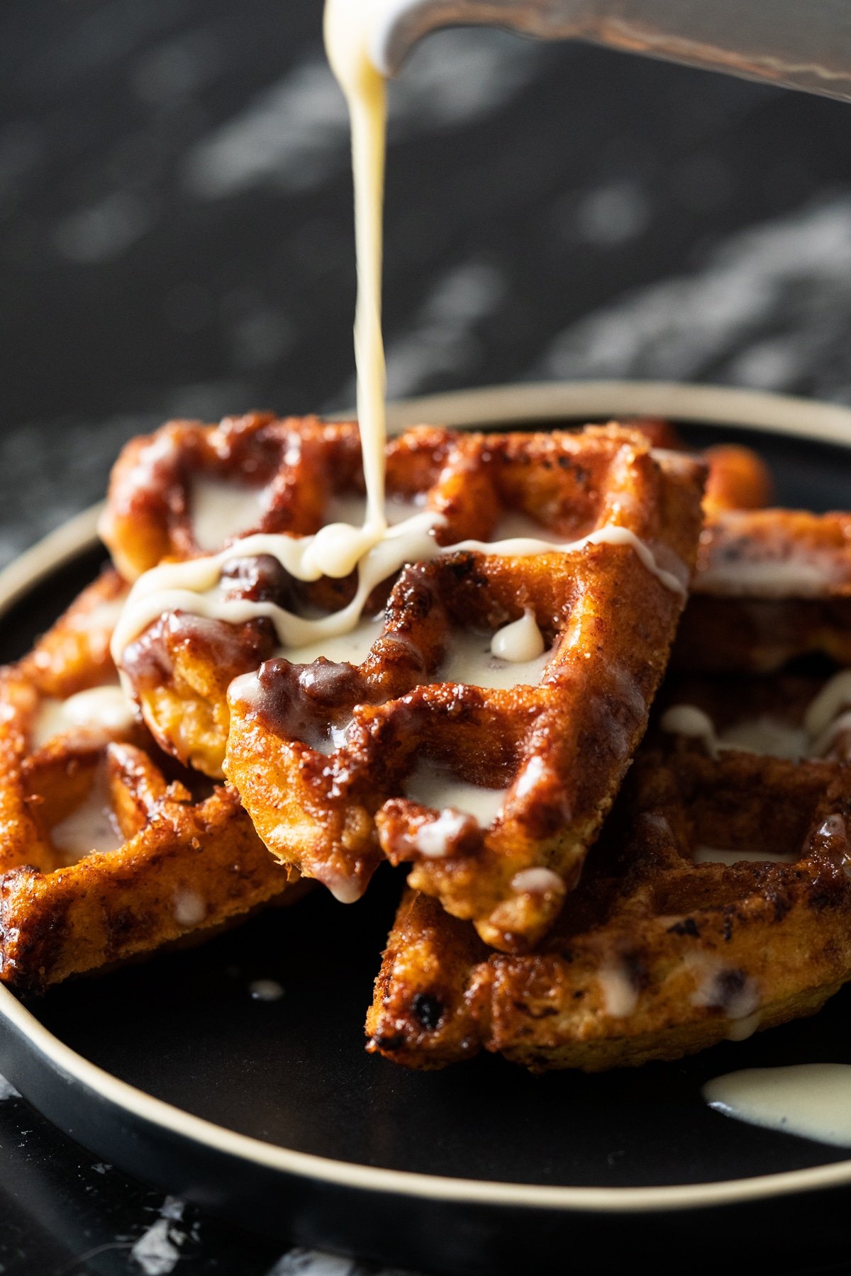 Gluten free & keto cinnamon roll waffles with yeast and a drizzle of cream cheese glaze