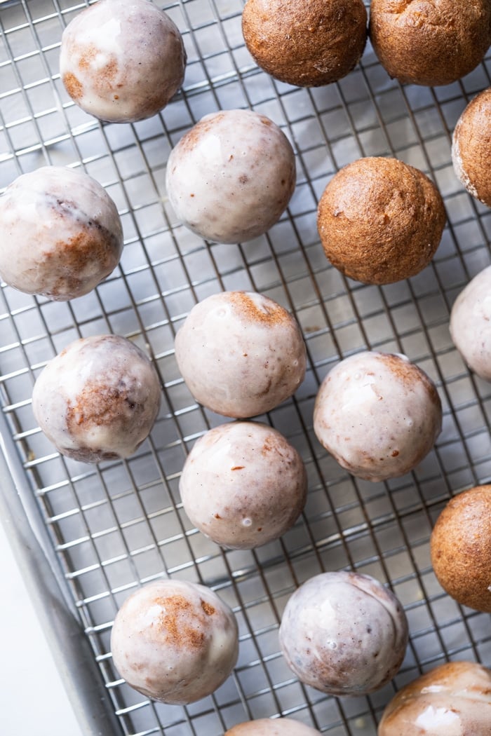 Freshly glazed keto donut holes on a rack