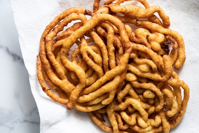 Freshly fried keto funnel cakes on a paper towel