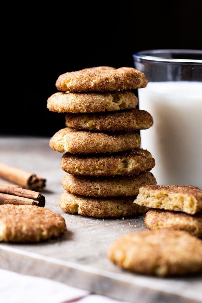 Piled up keto snickerdoodle cookies with a glass of milk