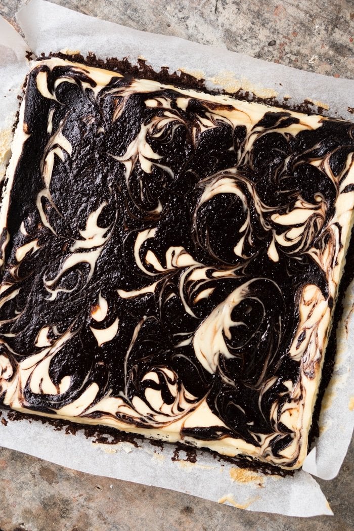 Overhead shot of keto cheesecake brownies post bake on parchement paper