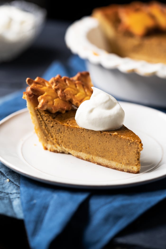 A slice of keto pumpkin pie with whipped cream