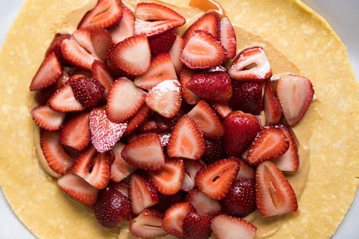 Piling strawberries on top of the peanut butter smeared pie crust