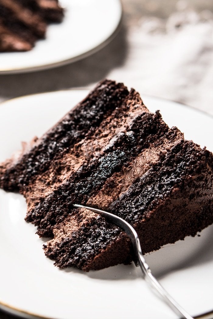 Taking a bite of a keto chocolate cake slice with a fork