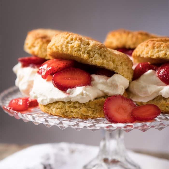 Keto strawberry shortcake with whipped cream on a cake platter