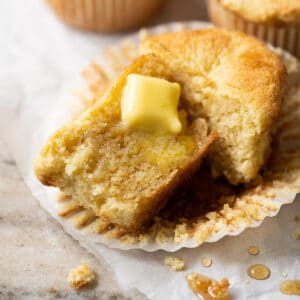 A halved keto cornbread muffin with a pat of butter melting through