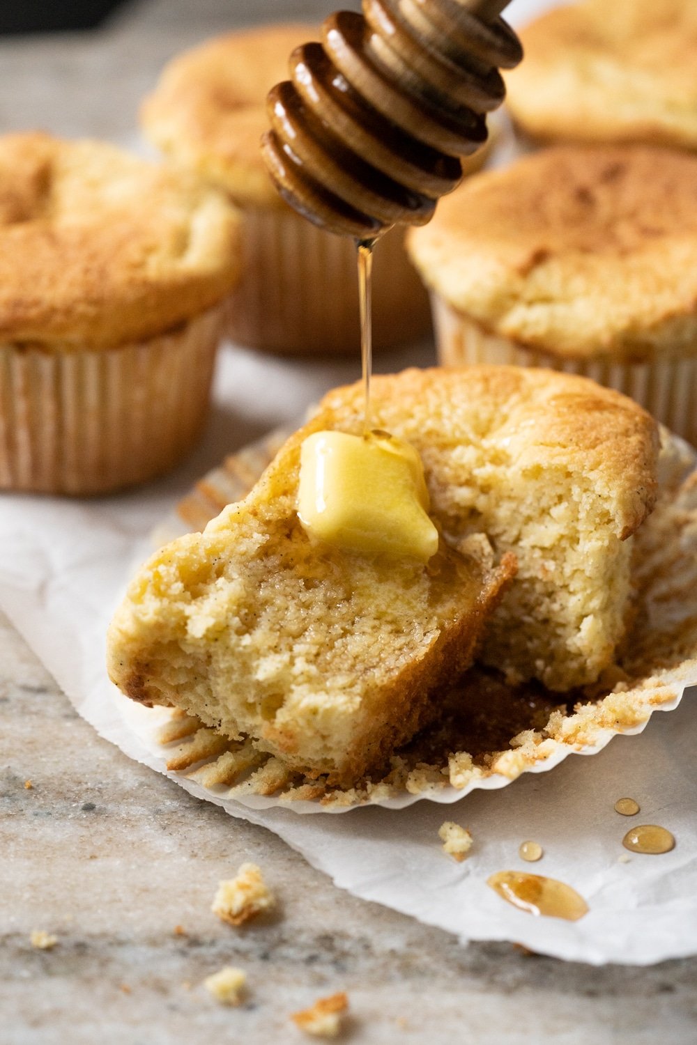 Drizzling keto maple syrup onto a halved low carb cornbread muffin