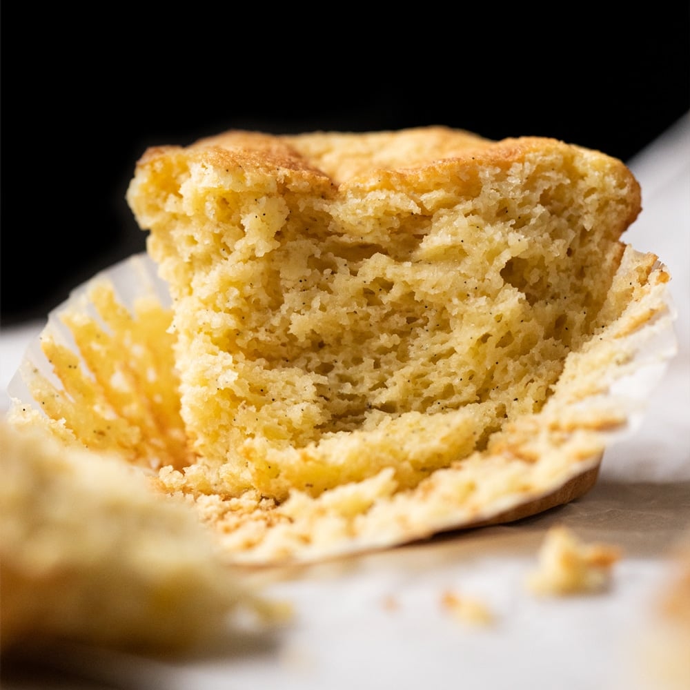 A pinched keto cornbread muffin showing the tender crumb