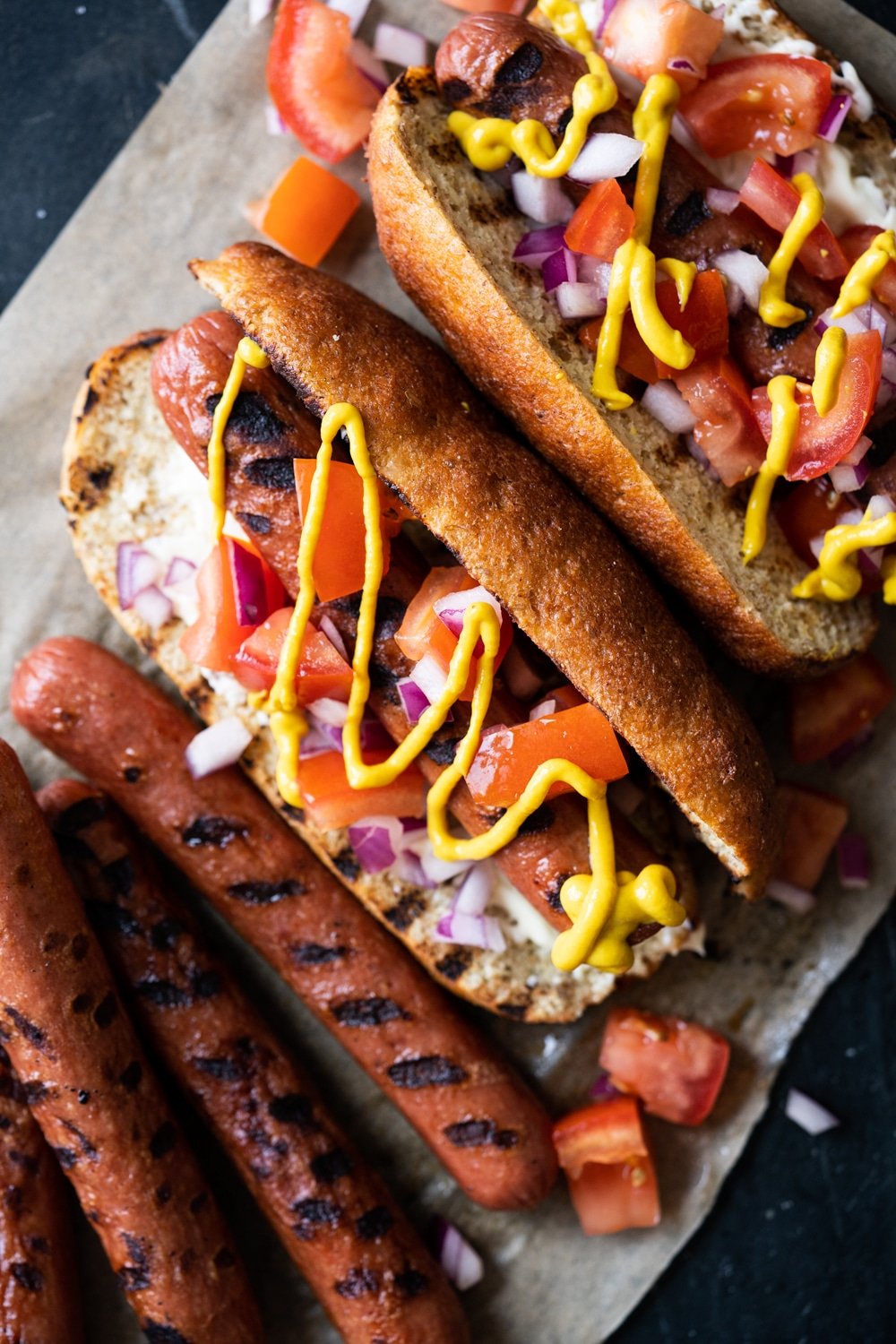Keto hot dogs with fluffy yeast buns, pico de gallo salsa and a drizzle of mustard