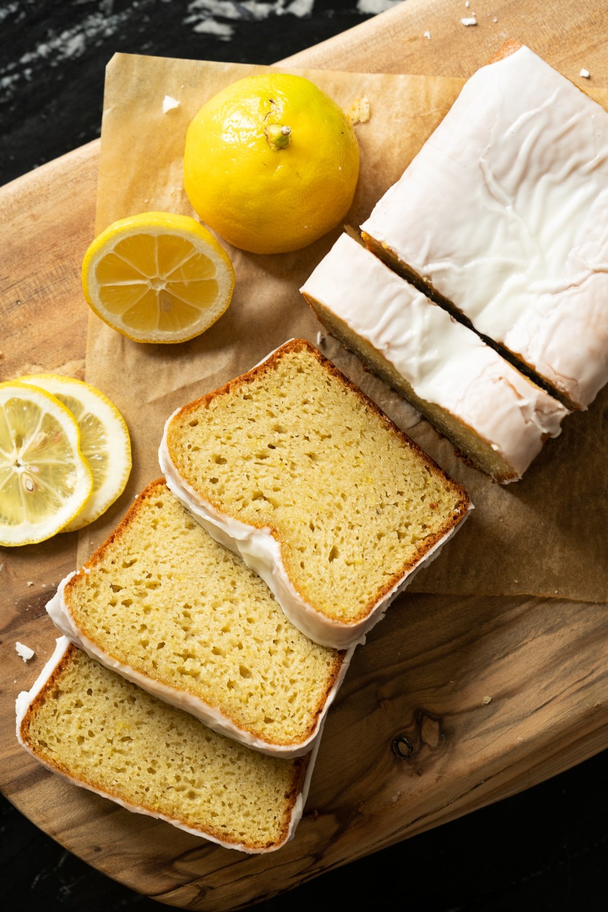 Three slices of iced keto lemon pound cake on a wooden board
