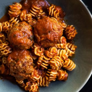 Keto meatballs with low carb radiator pasta in a green bowl