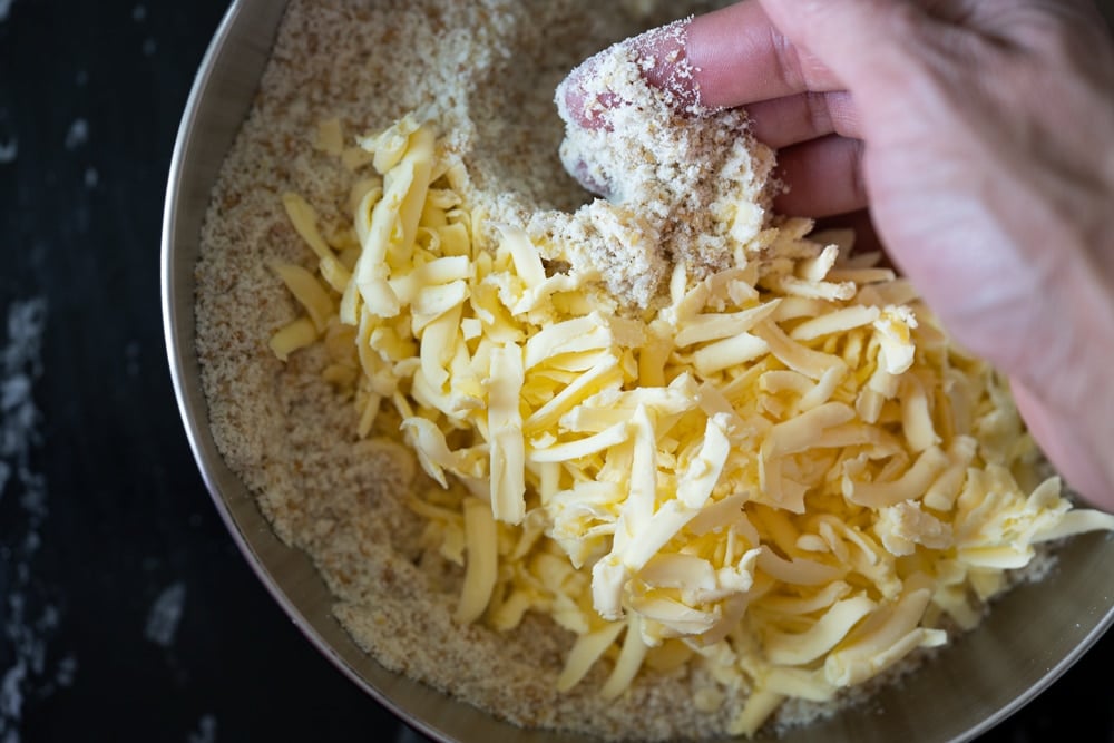 Mixing grated butter with keto flours for shortcakes