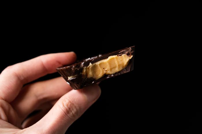 Holding a bitten keto peanut butter cup showing creamy texture