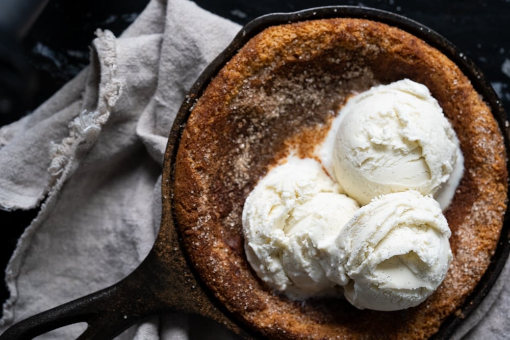 Freshly baked keto snickerdoodle skillet cookie with three scoops of vanilla ice cream