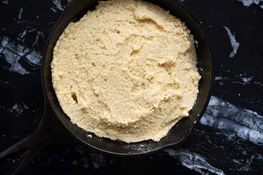 Flattening the keto snickerdoodle cookie dough in an 8 inch skillet