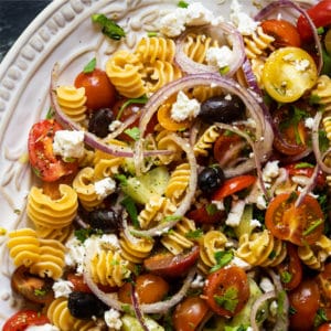 Keto pasta salad with cherry tomatoes on a white serving platter