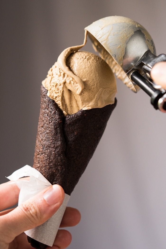 Scooping keto ice cream onto a chocolate cone