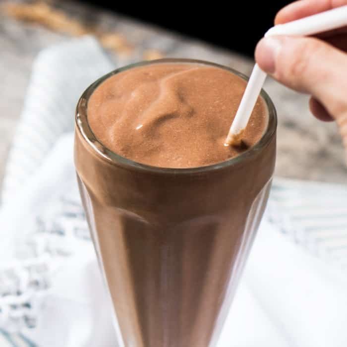 Drinking a keto chocolate milkshake with a straw