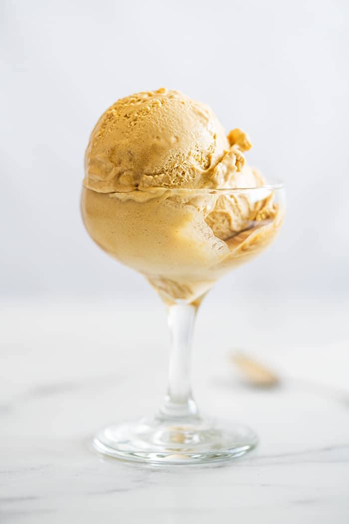 Two scoops of keto salted caramel ice cream in a glass cup